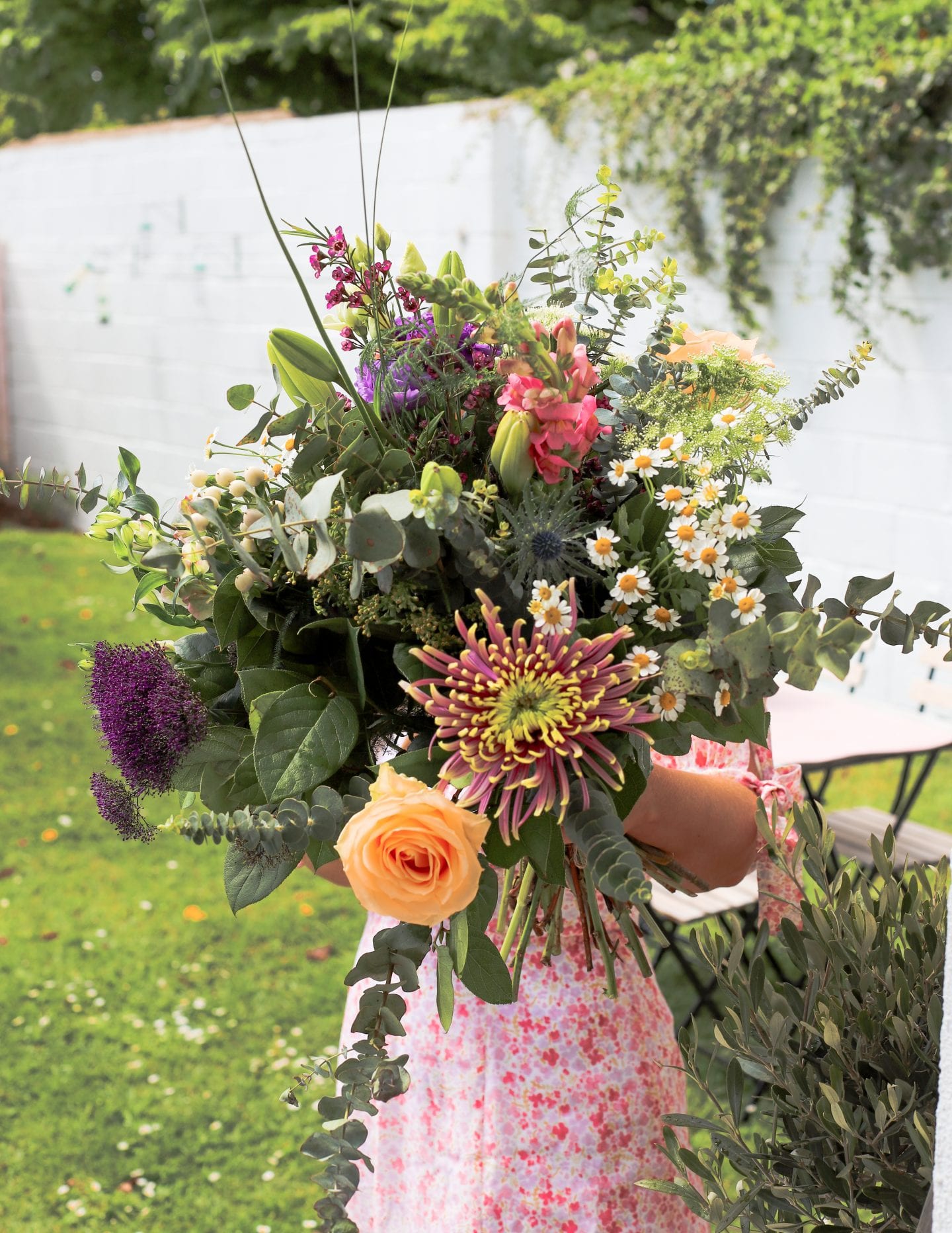 Large cottage floral bouquet with girl in floral dress. 