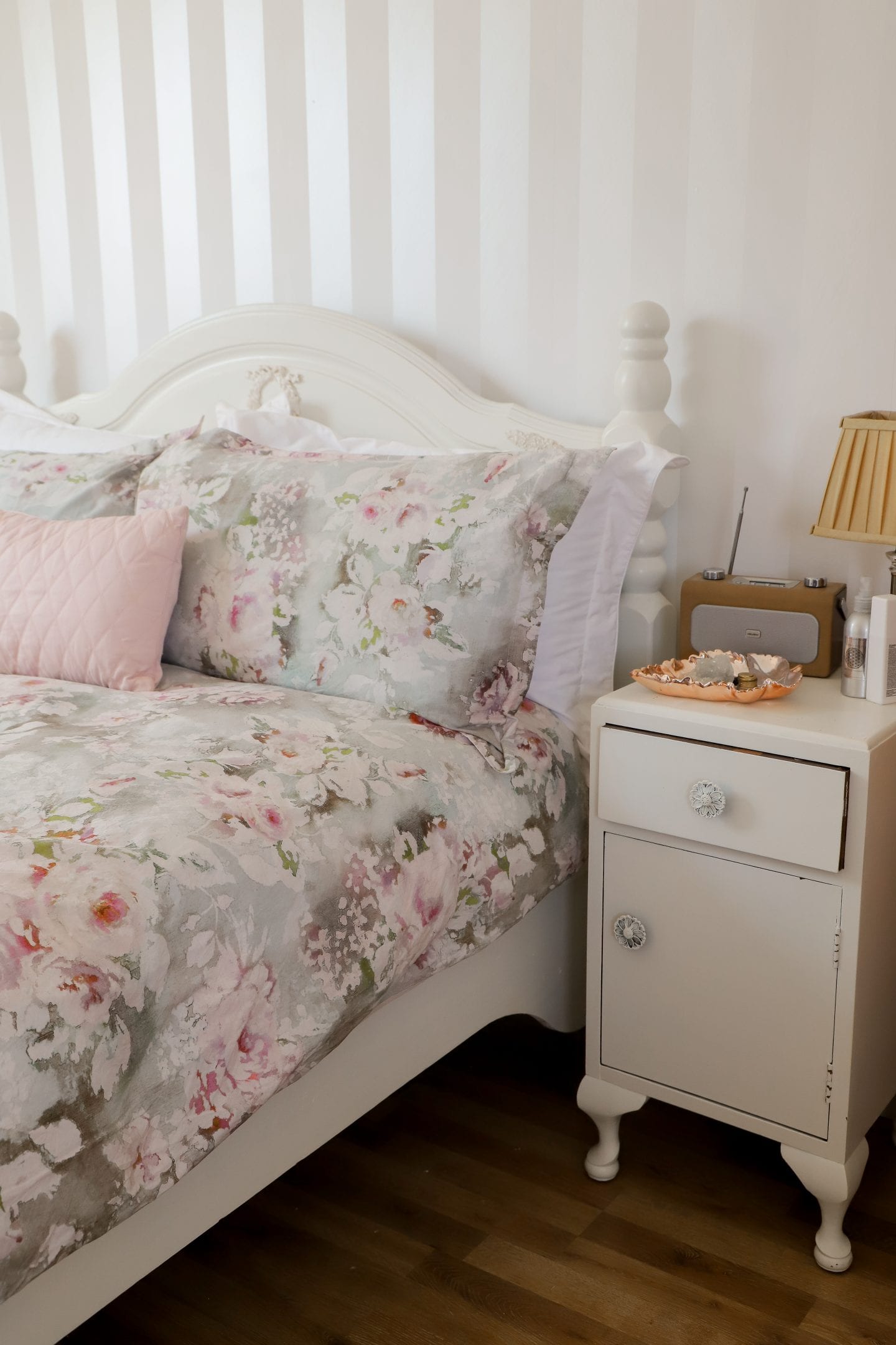 Floral bedsheets on white bed. How to dispose of mattress in Ireland.